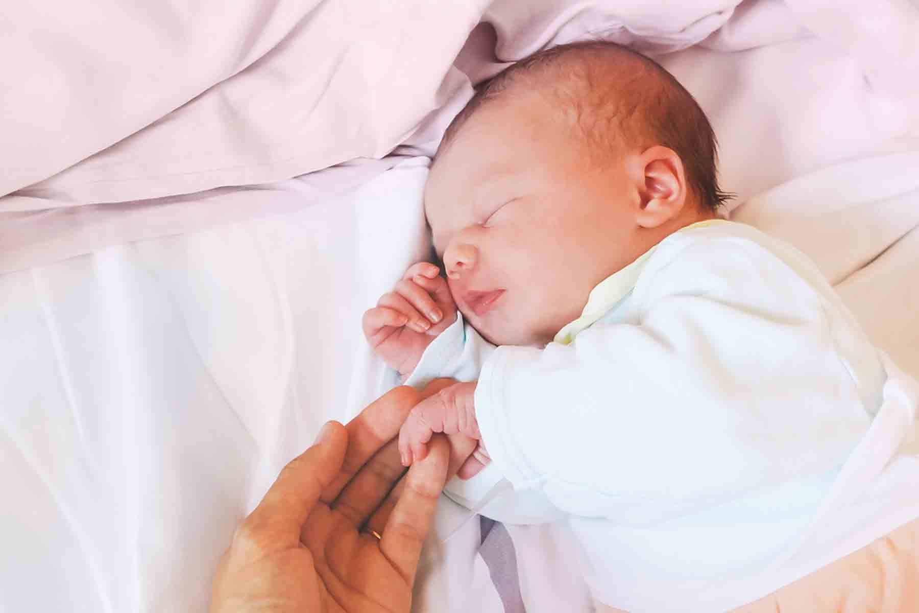 A mom holding a baby in the nursery