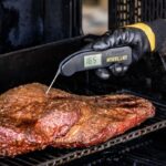 Close-up of brisket being probed with a meat thermometer
