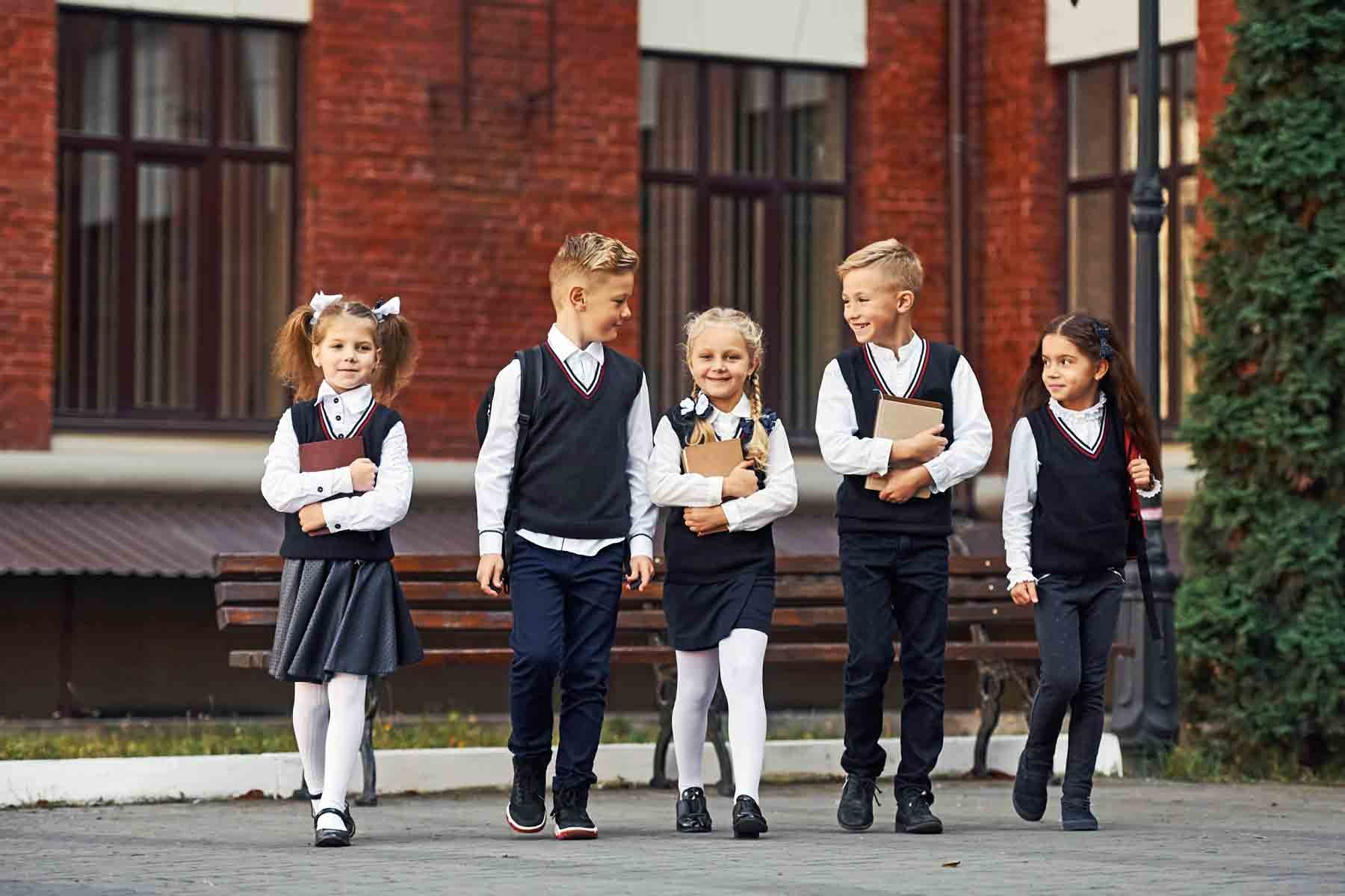 Students in private school uniforms working on a science project together.